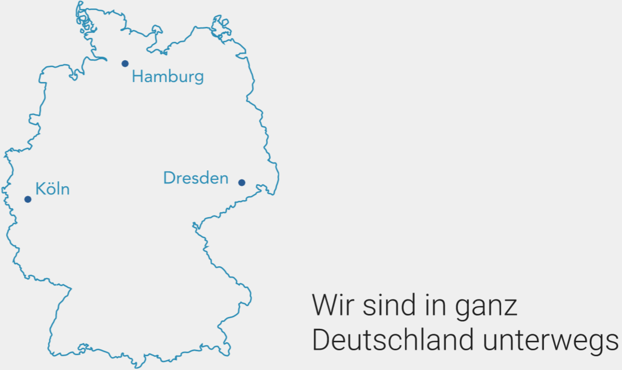 Foto von einem Handy auf dessen Bildschirm ein Mann bei einem Graffiti stehend zu sehen ist.